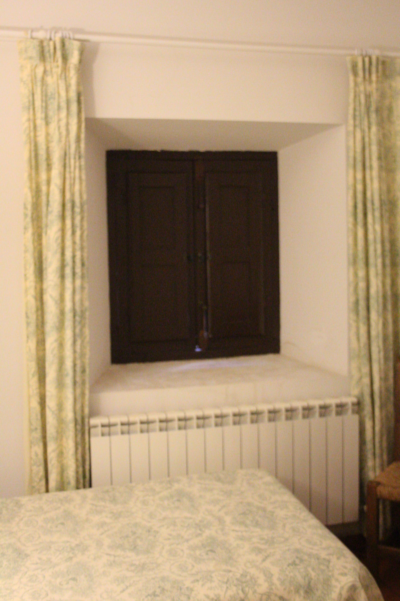 Ventana con contraventanas de madera restauradas